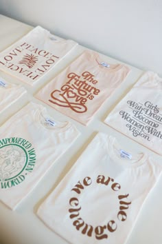 six t - shirts with different designs on them sitting on top of a white table