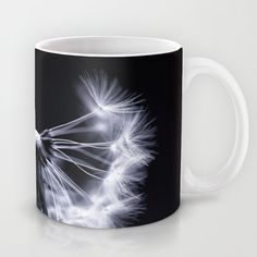 a black and white photo of a dandelion in full bloom on a coffee mug