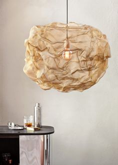 a light that is hanging from the ceiling in a room with white walls and furniture