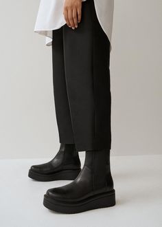 Meet Tara, the go-to statement boots. This modern take on the classic Chelsea boot is made from smooth black leather set on a chunky, yet light, flatform sole measuring 55 mm. Details include elasticated inserts and pull tabs back for easy wear and removal. Black leather Mid-high shaft Elastic side panels 55mm platform soles Pull-on tabs For long-lasting care: use a black shoe cream and protector spray to ensure a longer lifespan. Shaft height: 202 mm Shaft width: 227 mm Heel height: 55 mm Vagabond Chelsea Boots, Lug Sole Chelsea Boots Outfit, Vagabond Boots, Black Flat Boots, Platform Boots Women, Chelsea Boots Outfit, Platform Chelsea Boots, Closed Toe Heels, Cream Shoes