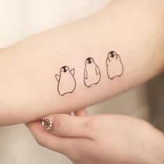 three small birds on the arm and one is drawn in black ink by someone's hand