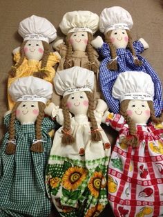 five cloth dolls with hats and aprons are lined up in a row on the floor