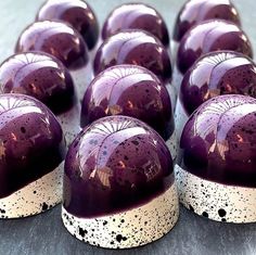 there are many purple and white chocolates on top of each other