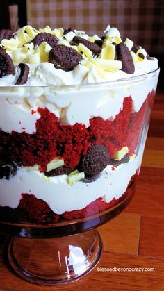 a red velvet trifle cake with white frosting and chocolate chips on the top