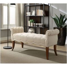 a white bench sitting in front of a book shelf