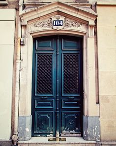 an old building with two blue doors and numbers on it