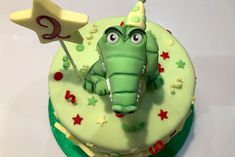 a green cake decorated with an alligator holding a flag