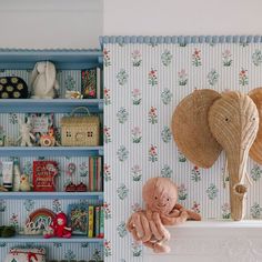 an elephant stuffed animal sitting on top of a shelf