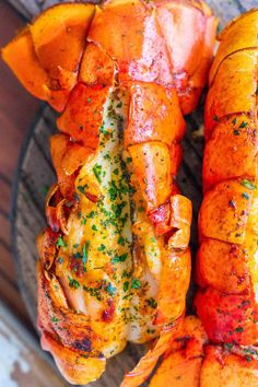 cooked lobsters and potatoes on a plate with parsley sprinkled on them