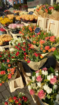 many different types of flowers and pies on display at a farmers'market stall