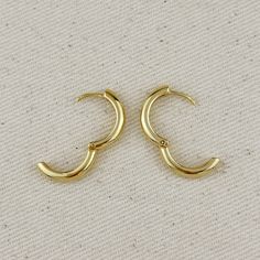 Elevate your style with these sleek 18k Gold Filled Polished Clicker Hoop Earrings. At 20mm in diameter, they're the perfect size for everyday wear, striking a balance between subtle and statement-making. The highly polished finish offers a radiant shine, while the secure clicker closure ensures easy wear and peace of mind. Metal: 18k Gold filled 20 mm external diameter x 3.5 mm wide Clicker type closure Hypoallergenic Water-resistant Handcrafted in Brazil Hand Chain Bracelet, 18k Gold Chain, Cubic Zirconia Necklace, Hand Chain, Emerald Jewelry, Anklet Jewelry, Earrings Collection, Cuff Bangles, Gold Filled Jewelry