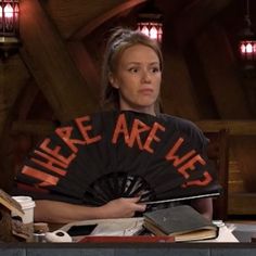 a woman sitting at a table with a fan in front of her and the words, there are lies on it