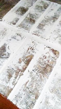 an old table is covered with white paint and brown wood planks that have been chipped off