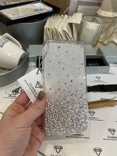 a person holding up a phone case with diamonds on it