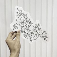 a person holding up a sticker with flowers on it