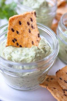 a small glass bowl filled with guacamole and tortilla chips on the side