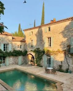 an outdoor swimming pool surrounded by stone buildings