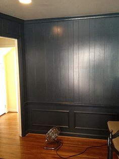 an empty room with wood paneling on the walls and hard wood floors in it