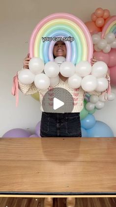 a woman holding balloons in front of her face