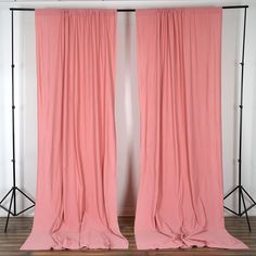 two pink curtains are open in front of a white wall