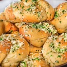 a bowl filled with rolls covered in cheese and herbs