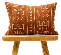 a brown and white pillow sitting on top of a wooden chair