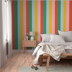 a bedroom with striped wallpaper and wooden flooring, white bedding and pillows