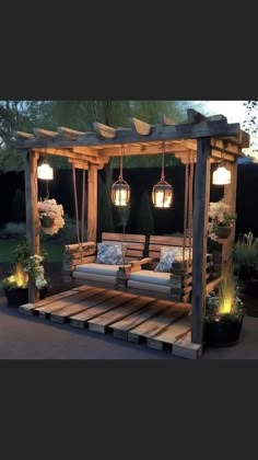 an outdoor seating area made out of pallets with lights hanging from the roof and wooden beams