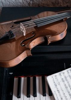 a violin sitting on top of a piano