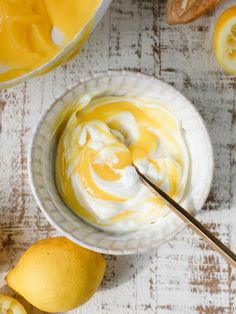 a bowl filled with yogurt next to sliced lemons