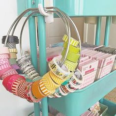 a rack filled with lots of different types of tapes and paper rolls on top of each other