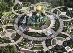 an aerial view of a building surrounded by greenery and stone walls, with several circular structures in the center