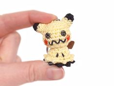 someone is holding a tiny crocheted animal