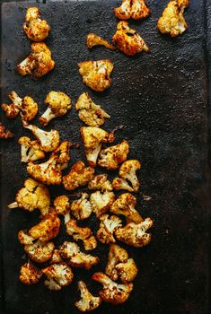 roasted cauliflower on a baking sheet ready to be cooked