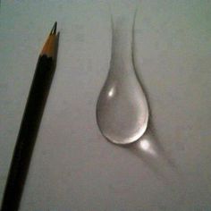 a pencil next to a drop of water