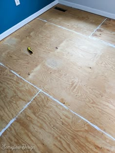 a room with blue walls and wood flooring that has been stripped off from the wall