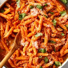 a pan filled with pasta and sauce covered in parmesan cheese