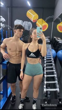 a man and woman taking a selfie in the gym