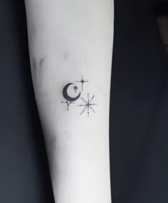 a person with a small tattoo on their arm and the moon is in the sky