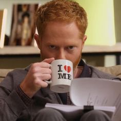 a man sitting on a couch holding a coffee mug