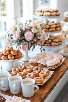 a table topped with lots of doughnuts and cups filled with coffee cupcakes