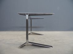 a metal table with two legs on the top and one leg raised up in the air