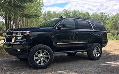 a black truck is parked in the dirt