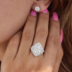 a close up of a person's hand with a diamond ring on her finger