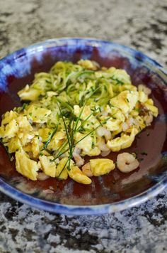 a blue bowl filled with food on top of a table