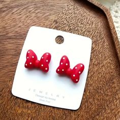 two red bows with white polka dots are sitting on a wooden table next to a card