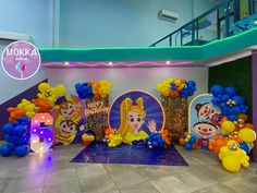 there are balloons and decorations on the floor in front of a wall with cartoon characters