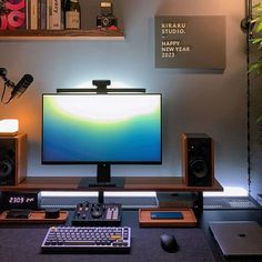 a computer monitor sitting on top of a desk next to speakers and a keyboard in front of it