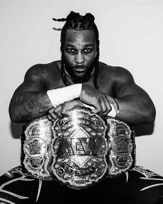 a black and white photo of a man holding a wrestling belt