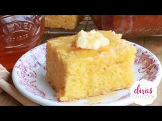 a piece of cake sitting on top of a plate next to a jar of honey